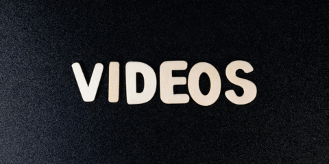 Close-up of the word 'videos' on black background