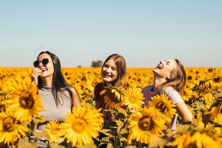 girls enjoying in sunflowers