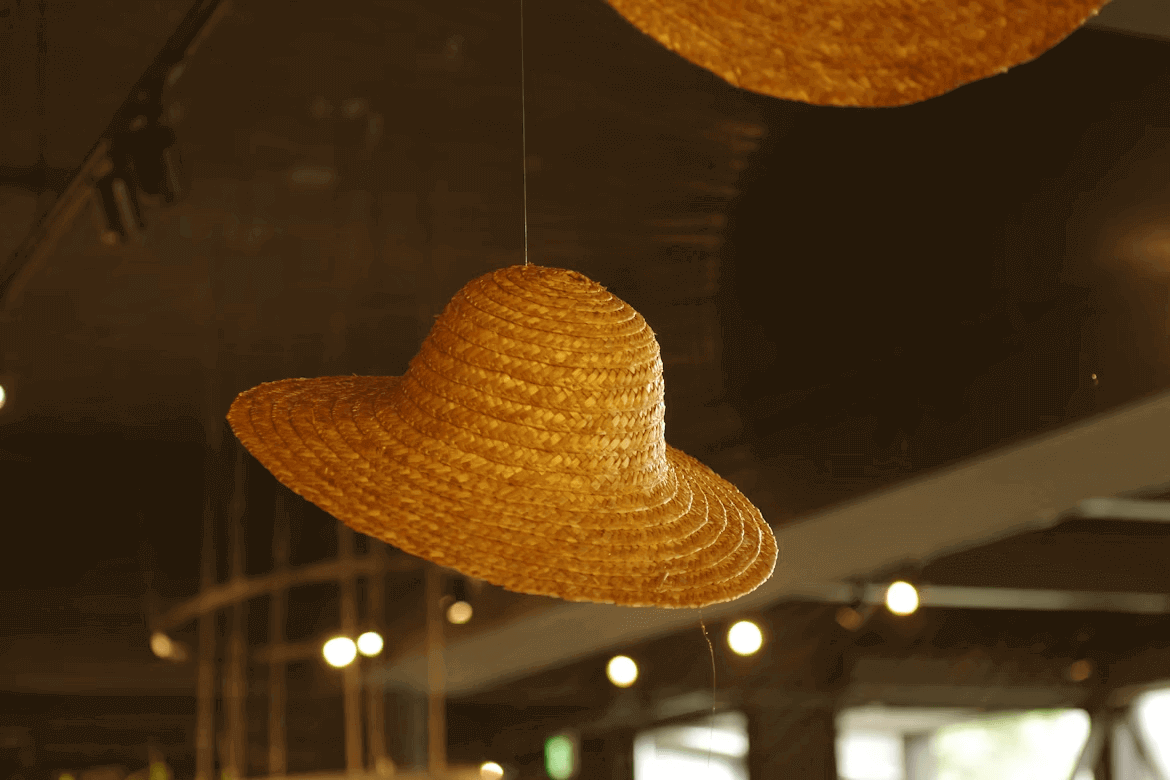 Straw hats hanging from ceiling as stylish decor