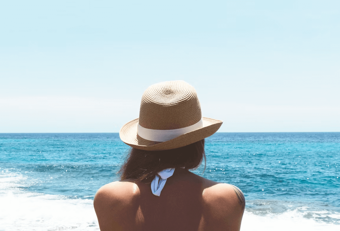 Woman in hat gazing at ocean
